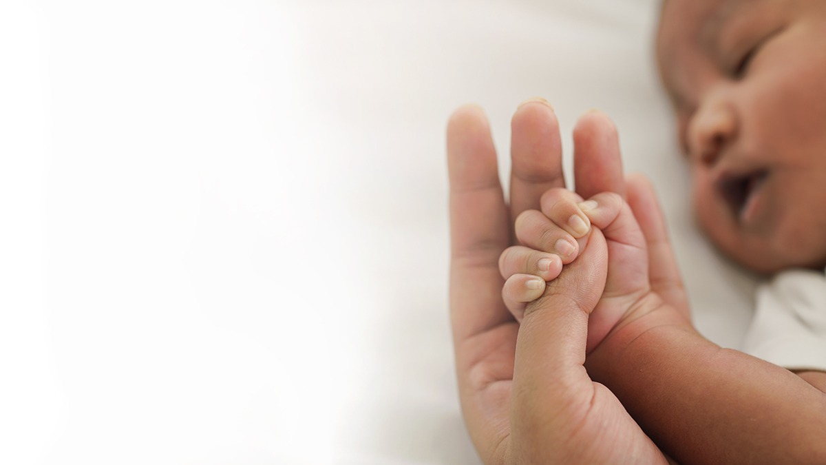 african american new born baby hand holding mom finger on white